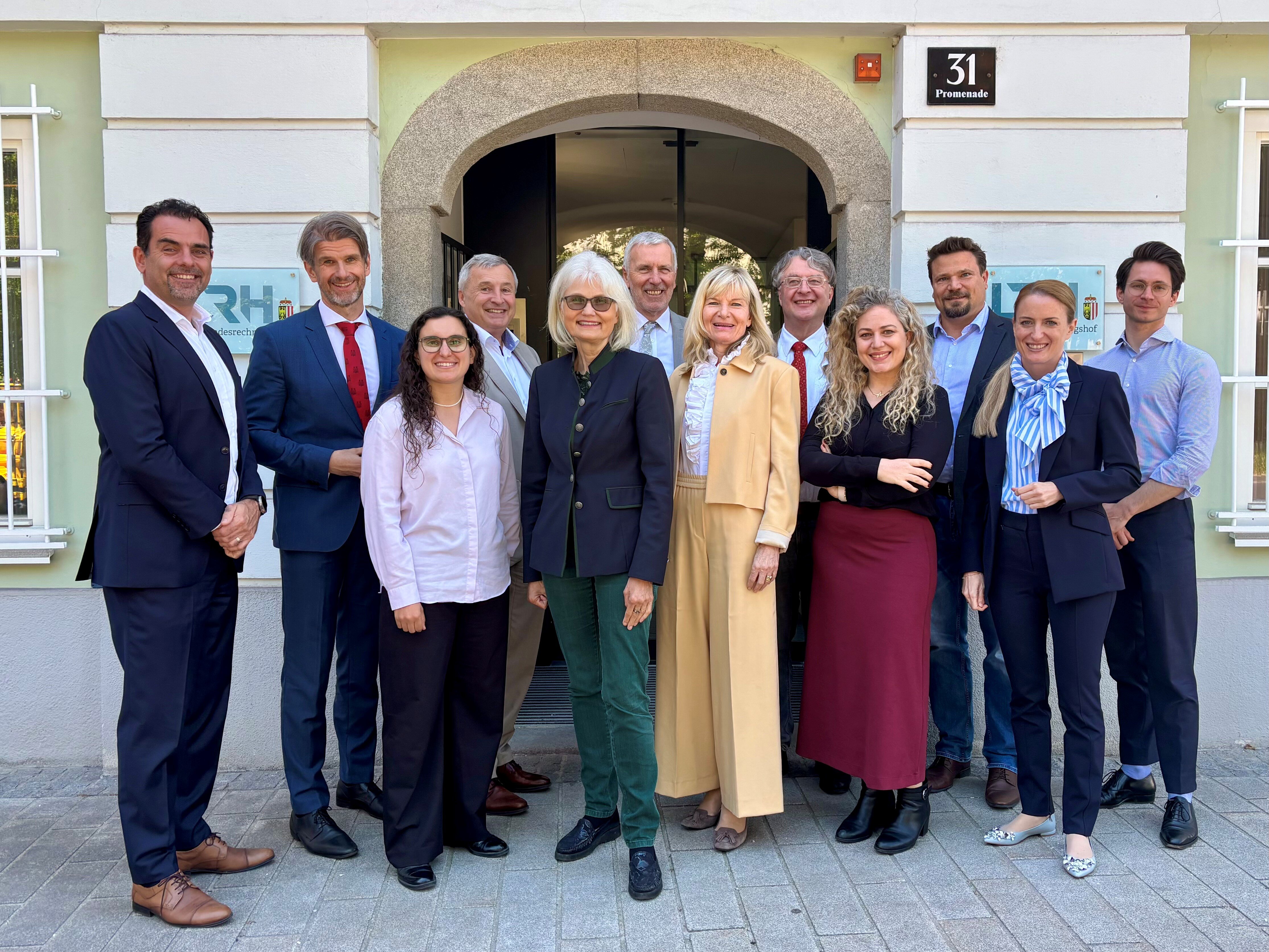 Gruppenfoto vor dem LRH OÖ in Linz mit allen Direktor:innen der Landesrechnungshöfe, die vor dem Eingangstor des LRH stehen