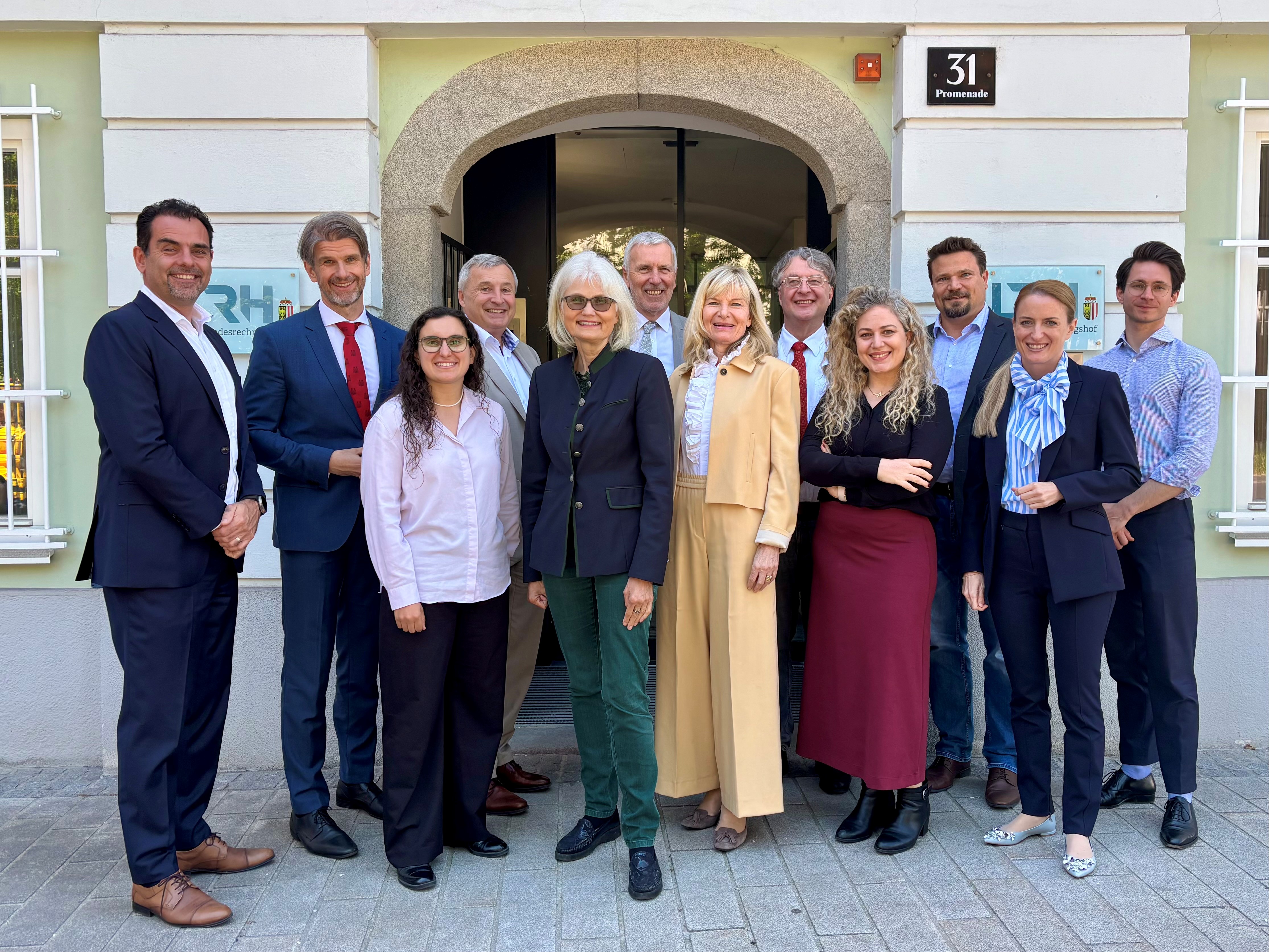 Gruppenfoto vor dem LRH OÖ in Linz mit allen Direktor:innen der Landesrechnungshöfe, die vor dem Eingangstor des LRH stehen